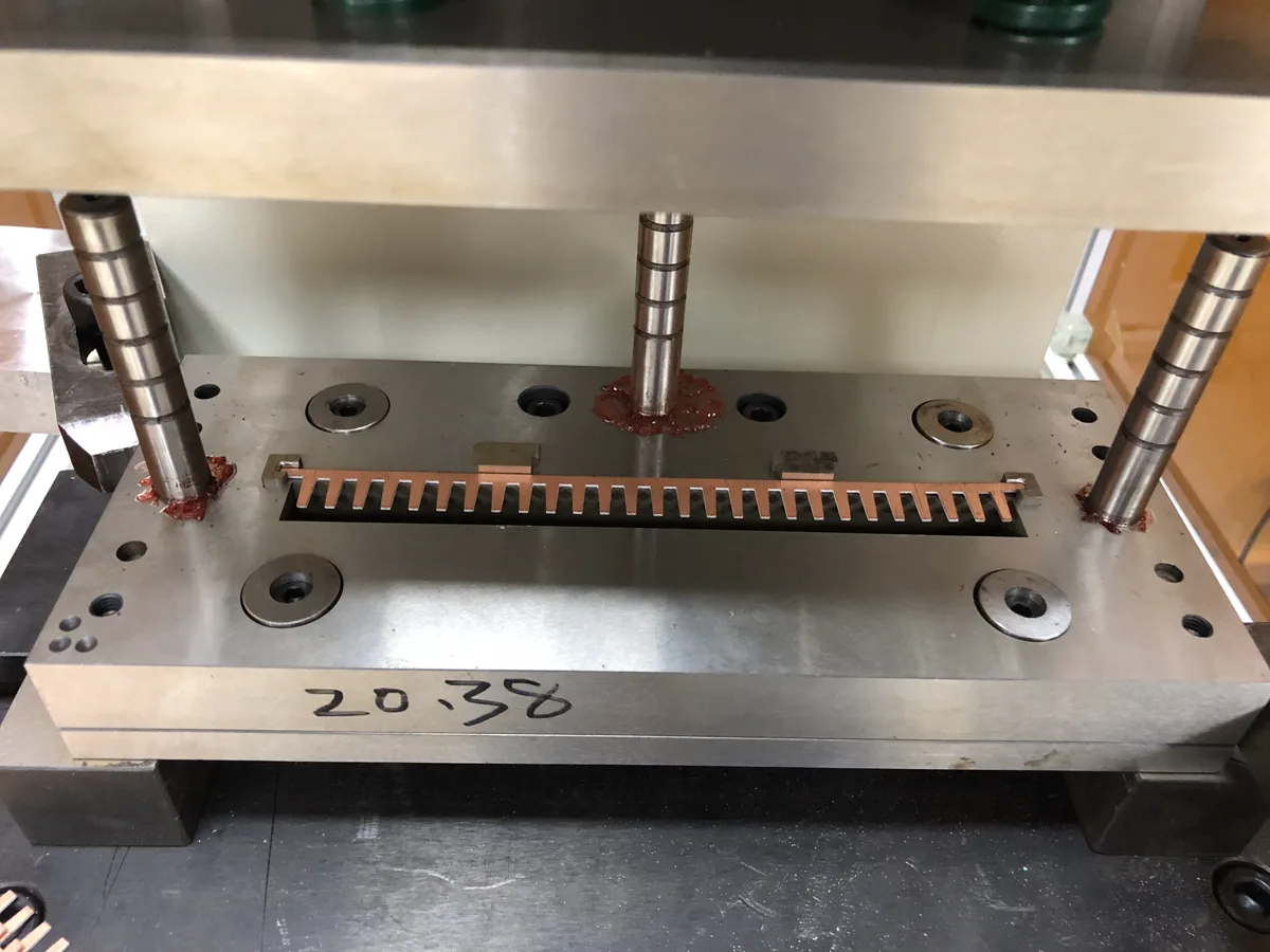 Hydro-pneumatic cylinder cutting copper electrical terminals in an automated station